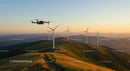 Drone Flying Over Wind Turbines on Scenic Hills at Sunset