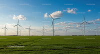 Wind Turbines on a Green Field Under a Blue Sky