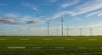 Wind Turbines on a Vast Green Field Under a Clear Blue Sky