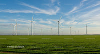 Wind Turbines on a Sunny Day Across a Vast Green Field