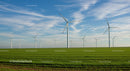 Wind Turbines Spinning Over Green Fields on a Sunny Day