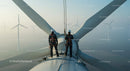 Engineers Inspecting Wind Turbine at Sunrise