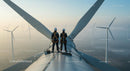 Engineers Inspecting Wind Turbine at Sunrise