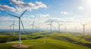 Wind Turbines Over Lush Green Hills Under Blue Sky