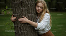 Blonde Woman Embracing Tree in Peaceful Green Park