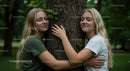Sisters Embracing a Tree in a Forest Setting