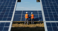 Engineers Inspecting Solar Panels at a Renewable Energy Farm