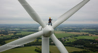 Technician Working on Wind Turbine Amidst Scenic Landscape