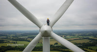 Technician Maintaining Wind Turbine on a Vast Wind Farm