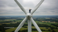Aerial Technician Working on Wind Turbine Amidst Green Landscape