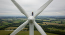 Worker on Wind Turbine Overlooking Countryside Landscape
