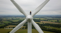 Worker on Wind Turbine Overlooking Countryside Landscape