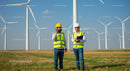 Engineers Inspecting Wind Turbines in a Field