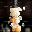 Close-Up of Falling Salt Crystals Against Dark Background