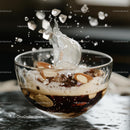 Splashing Beverage with Ice and Almonds in Glass