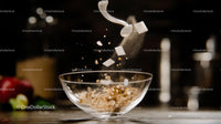 Sugar Cubes Splashing into Glass Bowl in Kitchen