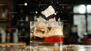 Refreshing Whiskey Splash with Ice Cubes in Bar Setting
