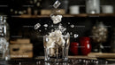 Ice Cubes Splashing into Whiskey Glass in Dark Bar