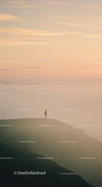 Silhouette of a Person on Mountain at Sunset