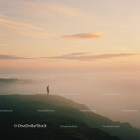 Person Standing on Foggy Cliff at Sunrise
