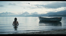 Woman Wading in Calm Lake with Rowboat and Mountain View