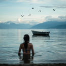 Woman in Water with Birds and Boat on Serene Lake
