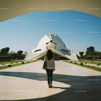 Person Walking Towards Modern Futuristic Architecture