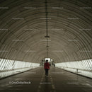 Person Walking Through Modern Arched Tunnel