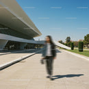 Blurred Figure Against Modern Architecture and Blue Sky