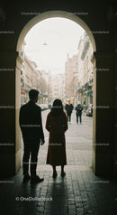 Silhouette of Couple Under Archway in Bustling City Street