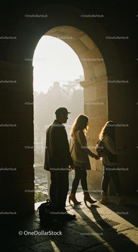 Silhouetted Trio Walking Through Sunlit Archway