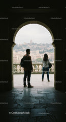 Silhouetted Couple Enjoying Cityscape from Historic Archway