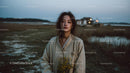 Pensive Woman Holding Yellow Wildflowers at Dusk