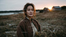 Pensive Woman Holding Yellow Wildflowers at Dusk