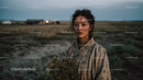 Pensive Woman Holding Yellow Wildflowers at Dusk
