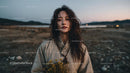 Pensive Woman Holding Yellow Wildflowers at Dusk