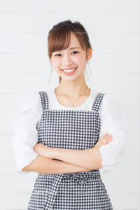 Smiling Woman in Gingham Dress with Arms Crossed
