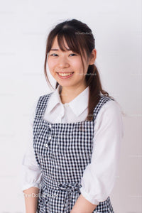 Smiling Woman in Checkered Dress and White Blouse