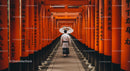 Man Walking Through Famous Torii Gates in Kyoto Shrine