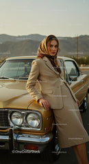 Elegant Woman in Beige Suit Leaning on Classic Car
