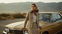 Elegant Woman Leaning on Classic Vintage Car in Desert Setting