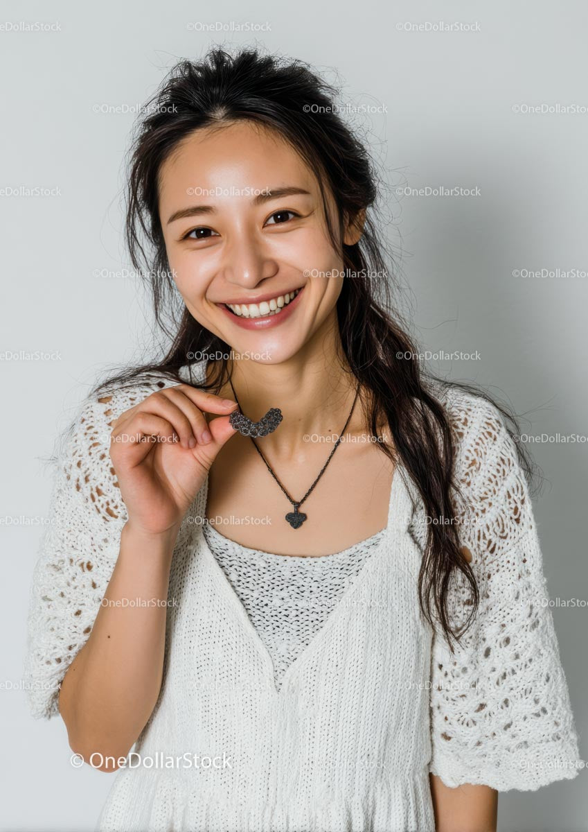 Joyful Woman Holding Necklace with a Bright Smile