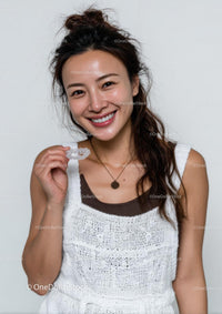 Smiling Woman Holding Clear Aligners for Dental Care
