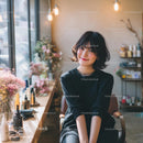 Smiling Woman in Cozy Cafe with Floral Decor
