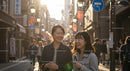 Smiling Friends Enjoying Stroll on Sunlit City Street