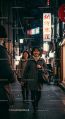 Smiling Friends Walking Through Vibrant City Streets at Night