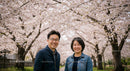 Smiling Couple Amidst Blooming Cherry Blossoms in Spring