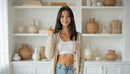 Smiling Woman in Cozy Sweater with Modern Bookshelf