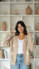 Smiling Woman in Cozy Beige Sweater Making Peace Sign