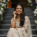Smiling Woman in Elegant Beige Sari with Floral Embellishments
